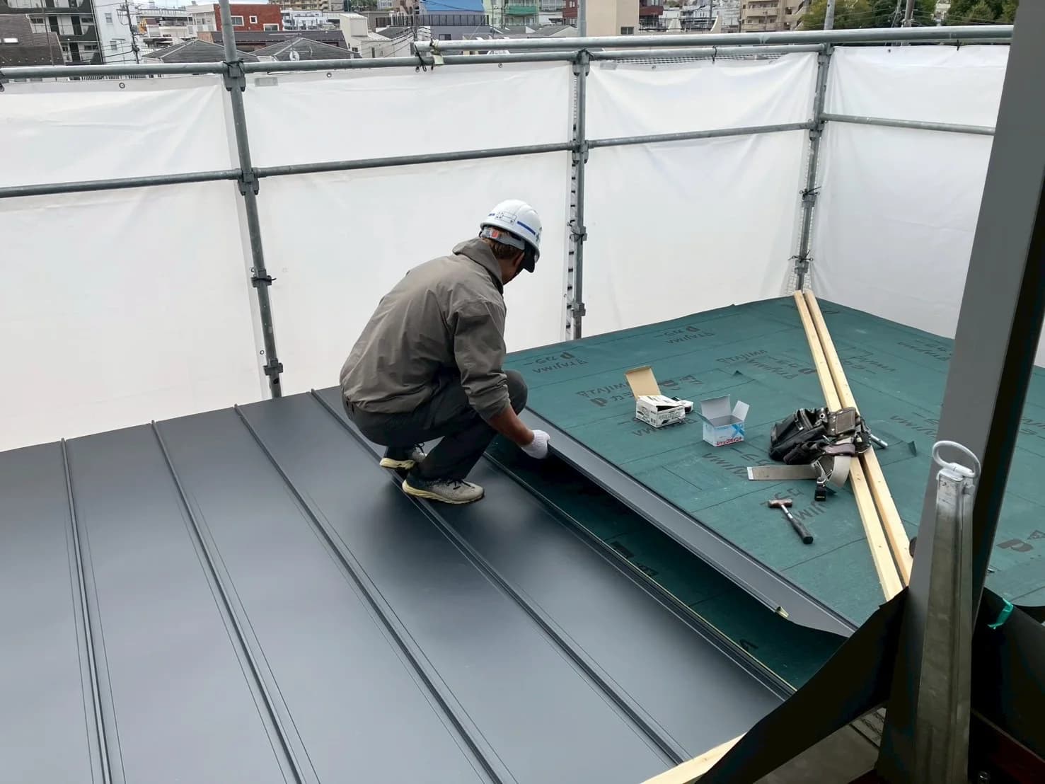 金属屋根材を施工する作業員